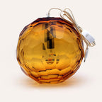 Medium amber spherical Murano glass pendant lamp with a hand-sculpted faceted surface, handcrafted on Murano Island in Venice, Italy.