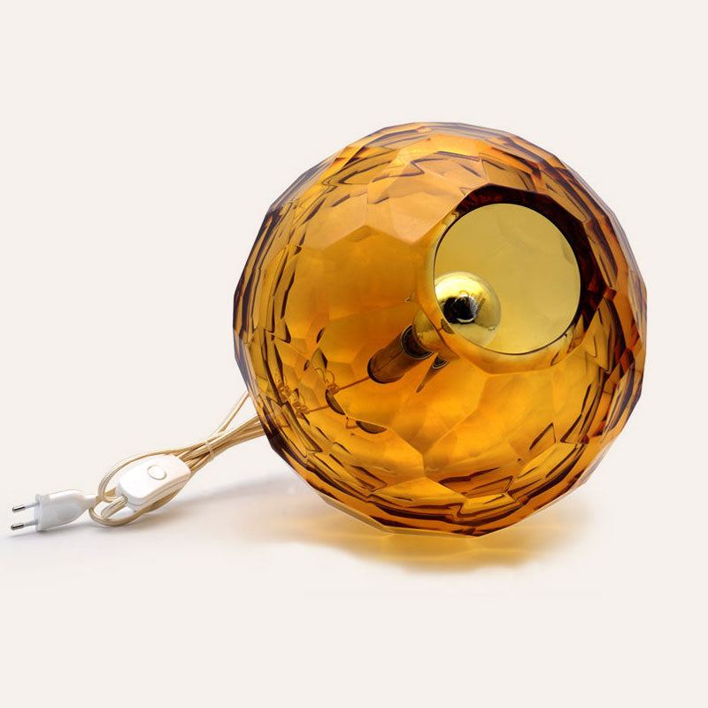 Medium amber spherical Murano glass table lamp with a hand-sculpted faceted surface, handcrafted on Murano Island in Venice, Italy.