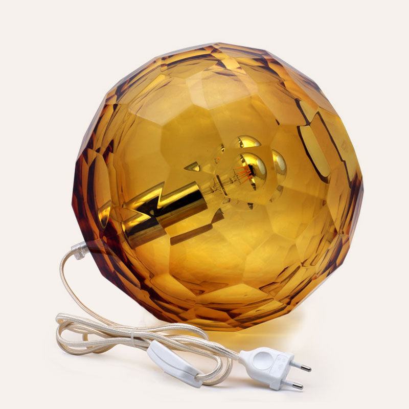 Medium amber spherical Murano glass table lamp with a hand-sculpted faceted surface, handcrafted on Murano Island in Venice, Italy.
